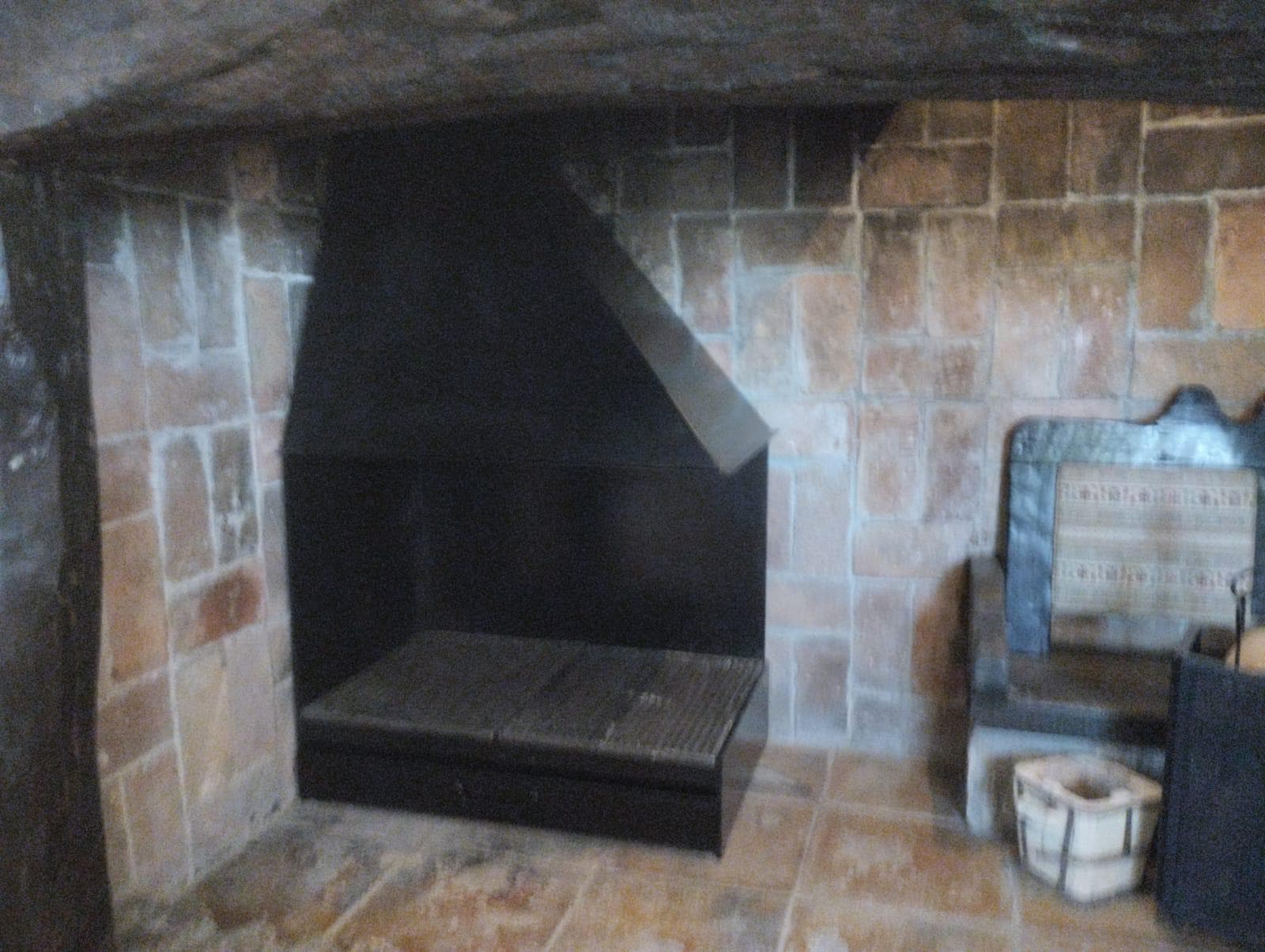 Casete de leña hecho a medida, instalado en un hogar de piedra