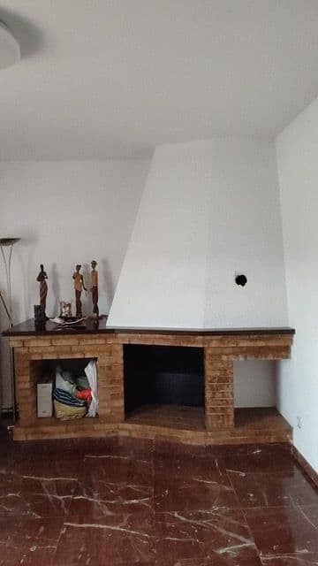 Chimenea de leña clásica de ladrillo, abierta y en esquina, antes de la reforma